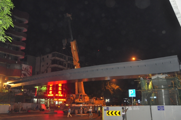 长38米、沉达87吨的钢箱梁，被200吨吊车稳稳地吊装在两个桥梁墩柱之上