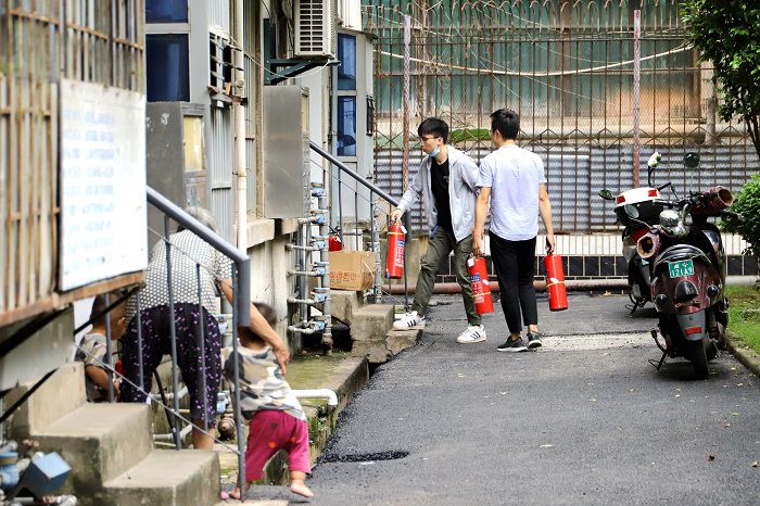 4.1服务队把灭火器按尺度放到每个单元3层楼的地位.JPG